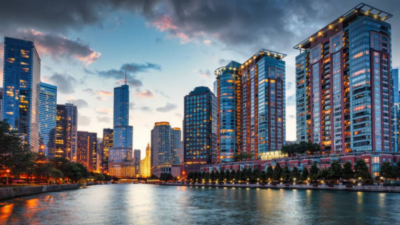 Chicago Urban Cityscape Sunset Twilight Panorama. Illuminated Chicago Urban Skyscrapers along the Chicago River. View from the Chicago River Waterfront at sunset twilight. Trump International Hotel and Tower in the background. Chicago, Illinois, USA, North America.