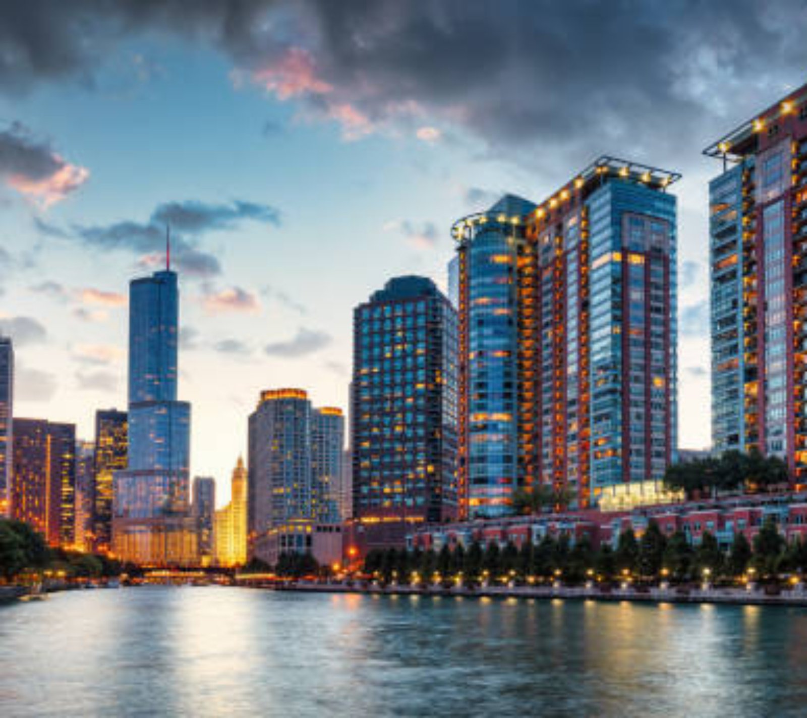 Chicago Urban Cityscape Sunset Twilight Panorama. Illuminated Chicago Urban Skyscrapers along the Chicago River. View from the Chicago River Waterfront at sunset twilight. Trump International Hotel and Tower in the background. Chicago, Illinois, USA, North America.