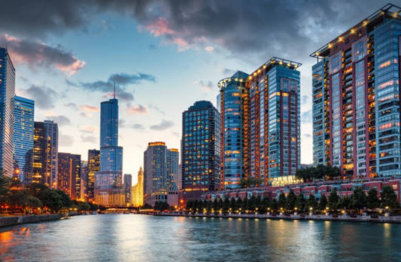 Chicago Urban Cityscape Sunset Twilight Panorama. Illuminated Chicago Urban Skyscrapers along the Chicago River. View from the Chicago River Waterfront at sunset twilight. Trump International Hotel and Tower in the background. Chicago, Illinois, USA, North America.